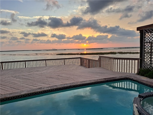 pool at dusk with a deck with water view