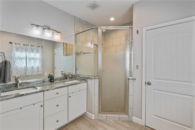 13950 Ketch St, Corpus Christi, TX 78418 - bathroom with a shower stall, double vanity, wood finished floors, recessed lighting, and baseboards