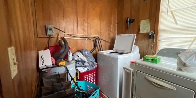 laundry room with separate washer and dryer and wooden walls