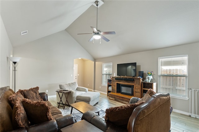 living room featuring high vaulted ceiling, light wood-type flooring, ceiling fan, and plenty of natural light