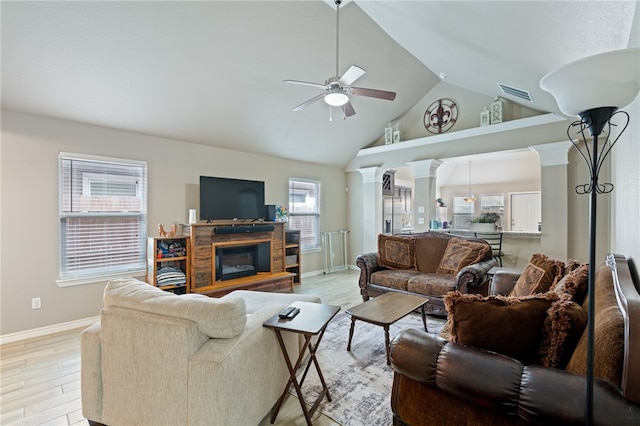 living room featuring ornate columns, light wood-type flooring, ceiling fan, and high vaulted ceiling