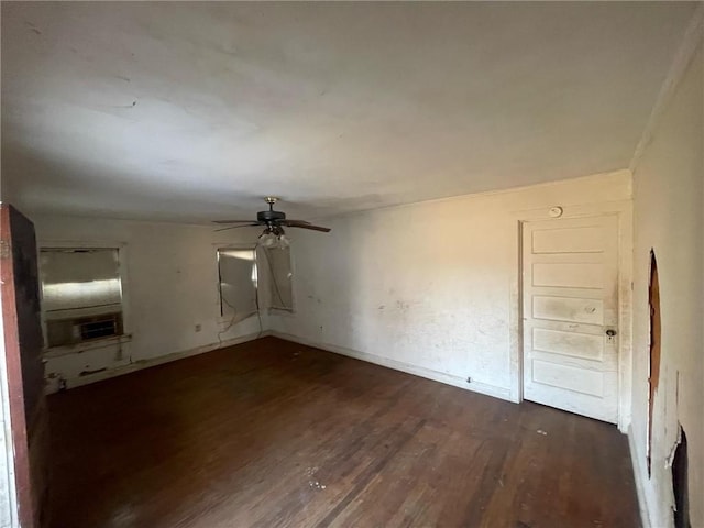 empty room featuring baseboards, ceiling fan, wood finished floors, and cooling unit