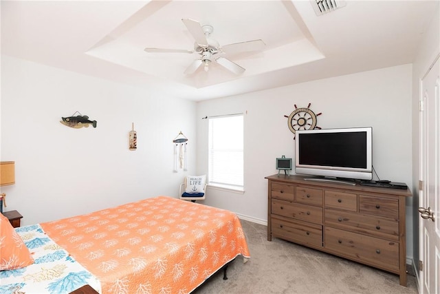 bedroom featuring ceiling fan, a raised ceiling, visible vents, and light colored carpet