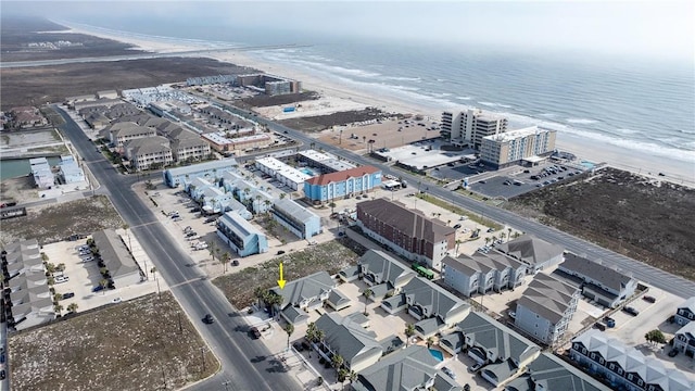 birds eye view of property with a water view and a view of the beach