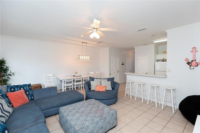 living room with light tile patterned floors, a ceiling fan, visible vents, and crown molding