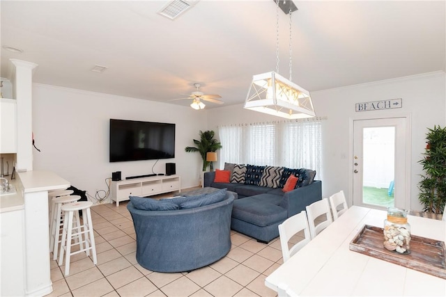 living area featuring light tile patterned floors, ceiling fan, visible vents, and crown molding