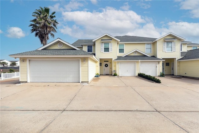 view of front of house with a garage, driveway, and fence