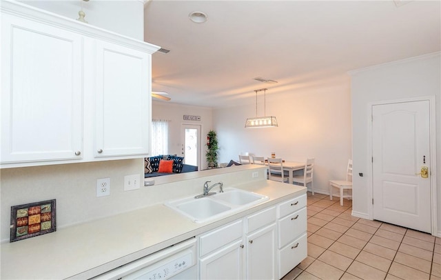 kitchen with light countertops, light tile patterned flooring, a sink, and white cabinets