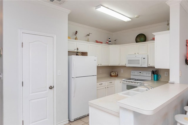 kitchen with a breakfast bar area, a peninsula, white appliances, a sink, and ornamental molding