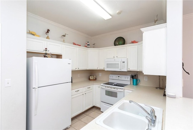 kitchen with light tile patterned floors, white appliances, a sink, light countertops, and crown molding