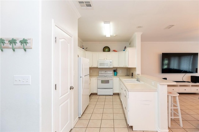 kitchen featuring light tile patterned floors, white appliances, a sink, visible vents, and a kitchen breakfast bar