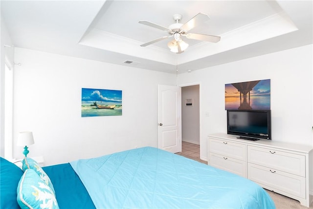 bedroom with visible vents, ornamental molding, a raised ceiling, and a ceiling fan