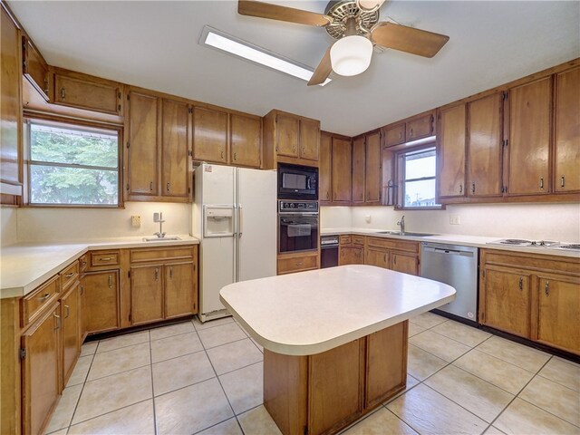 kitchen with black appliances, sink, ceiling fan, and light tile patterned floors