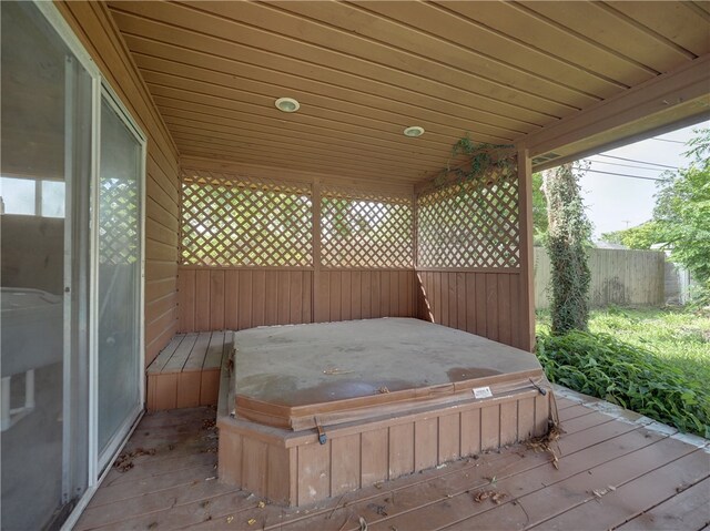 wooden deck with a covered hot tub