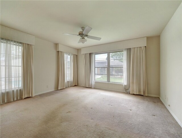 carpeted spare room with ceiling fan