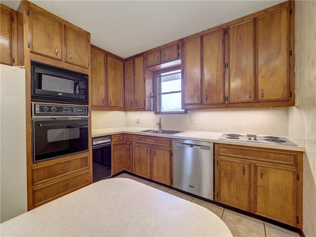 kitchen featuring light tile patterned floors, sink, and black appliances