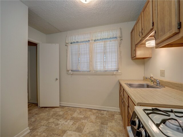 kitchen with a textured ceiling, sink, and white range