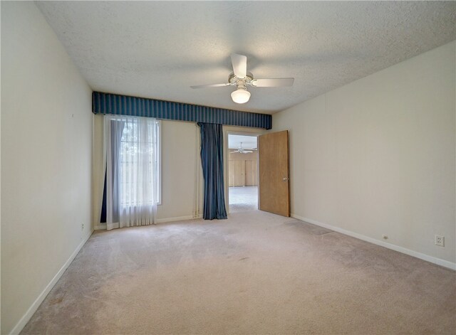 carpeted empty room featuring ceiling fan and a textured ceiling