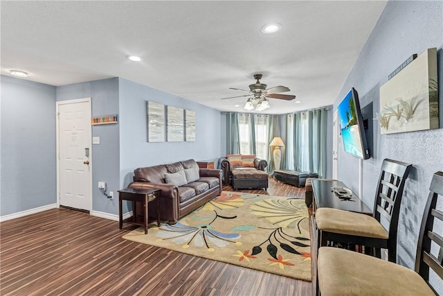 living room with ceiling fan and dark hardwood / wood-style floors