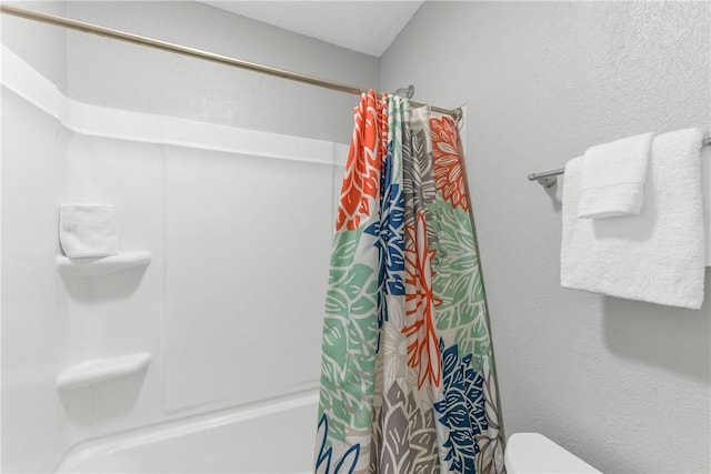 bathroom with toilet and shower / bath combination with curtain