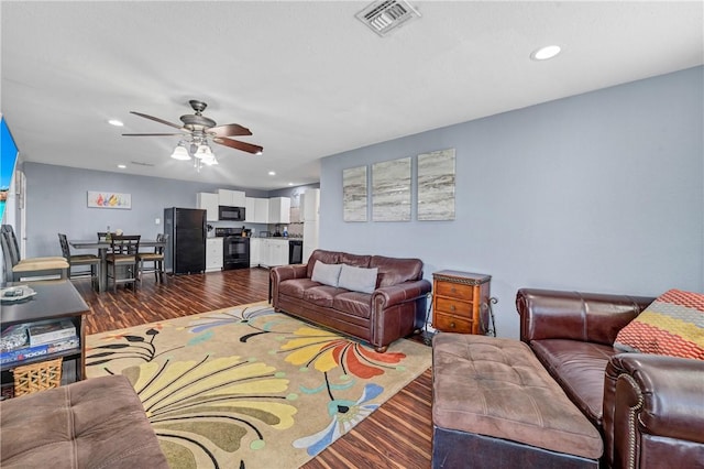 living room featuring ceiling fan and hardwood / wood-style floors