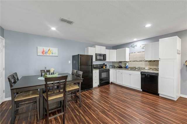 kitchen featuring black appliances, dark wood-type flooring, white cabinetry, decorative backsplash, and sink