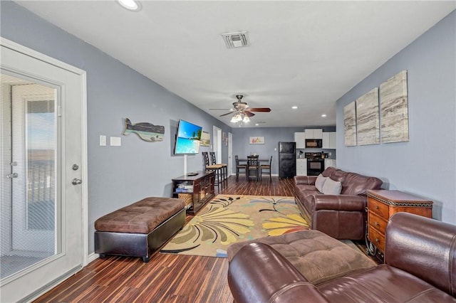 living room featuring ceiling fan and dark wood-type flooring