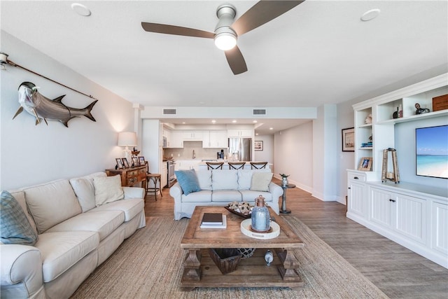 living room with ceiling fan and hardwood / wood-style flooring