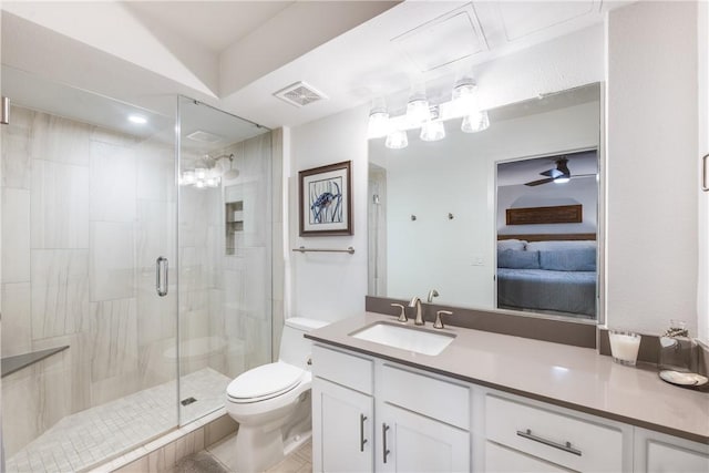 bathroom featuring tile patterned flooring, toilet, vanity, ceiling fan, and a shower with door