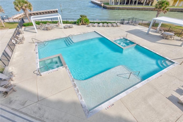 view of swimming pool with a hot tub, a pergola, a water view, and a patio area