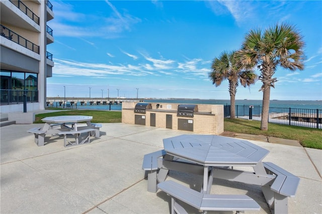 view of patio / terrace with an outdoor kitchen, area for grilling, and a water view