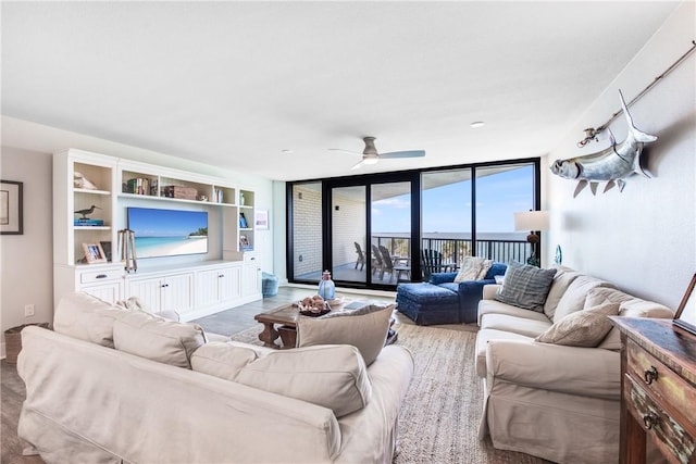 living room with ceiling fan, floor to ceiling windows, and light hardwood / wood-style flooring