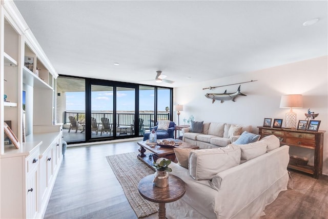 living room featuring ceiling fan, hardwood / wood-style flooring, and expansive windows