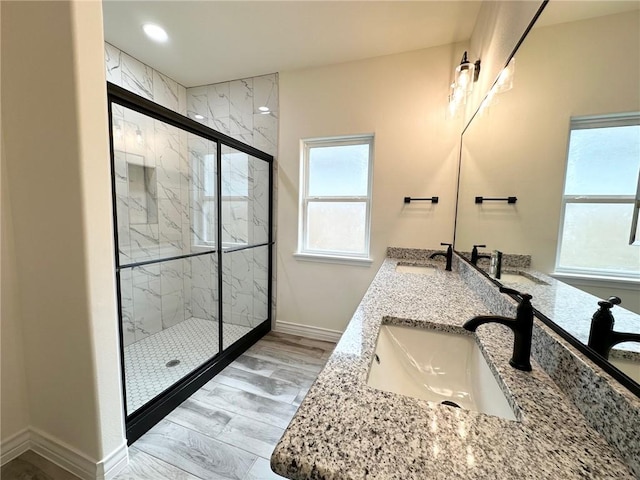 bathroom with plenty of natural light, a marble finish shower, and a sink