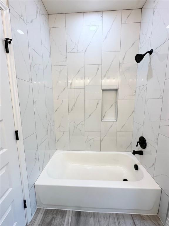 bathroom featuring wood finished floors and shower / bathing tub combination