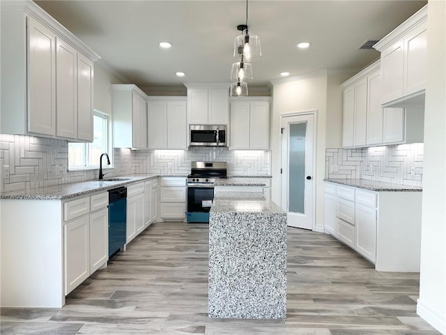 kitchen with crown molding, tasteful backsplash, appliances with stainless steel finishes, white cabinets, and a sink