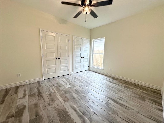 unfurnished bedroom with a ceiling fan, baseboards, and wood finished floors