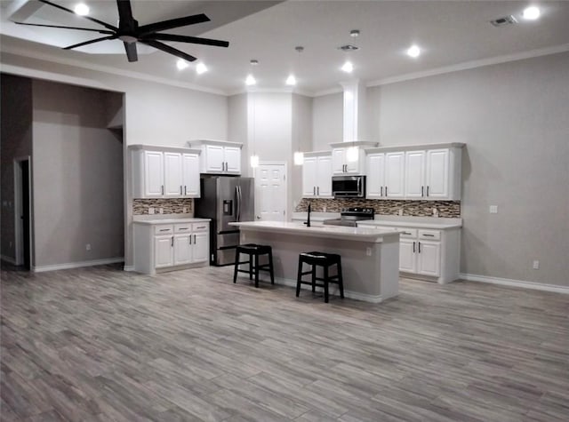 3141 Quail Springs Rd Unit 14, Corpus Christi, TX 78414 - kitchen with stainless steel appliances, ornamental molding, a kitchen breakfast bar, open floor plan, and decorative backsplash