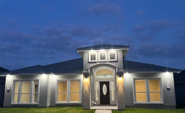 3141 Quail Springs Rd Unit 14, Corpus Christi, TX 78414 - back of house at twilight with roof with shingles, stucco siding, and a lawn