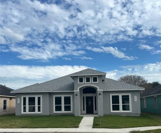 3141 Quail Springs Rd Unit 14, Corpus Christi, TX 78414 - view of front facade featuring a shingled roof, stucco siding, and a front yard