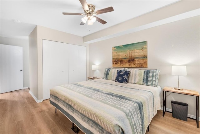 bedroom featuring a closet, ceiling fan, baseboards, and wood finished floors