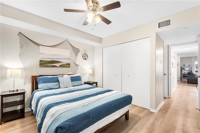 bedroom featuring a closet, visible vents, light wood-style flooring, and baseboards