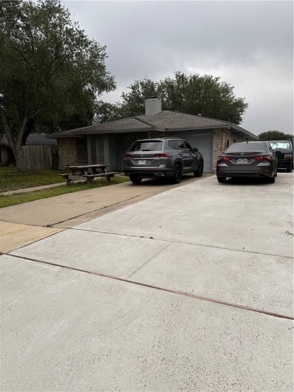 exterior space with driveway, brick siding, and a garage