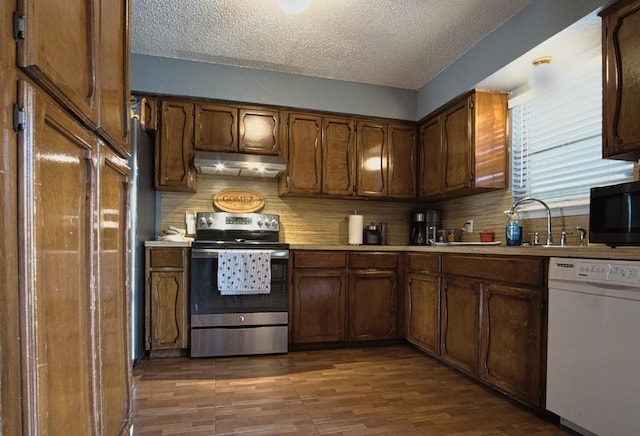 2850 Tuscarora Dr, Corpus Christi, TX 78410 - kitchen with electric range, white dishwasher, under cabinet range hood, a textured ceiling, and light countertops