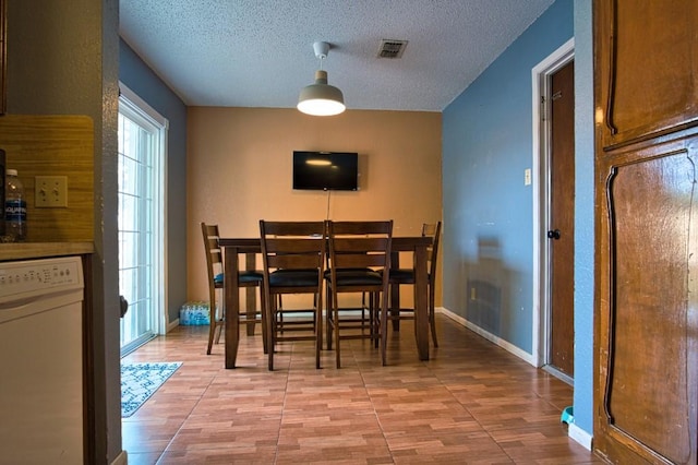 2850 Tuscarora Dr, Corpus Christi, TX 78410 - dining room featuring light wood-style flooring, a textured ceiling, and baseboards
