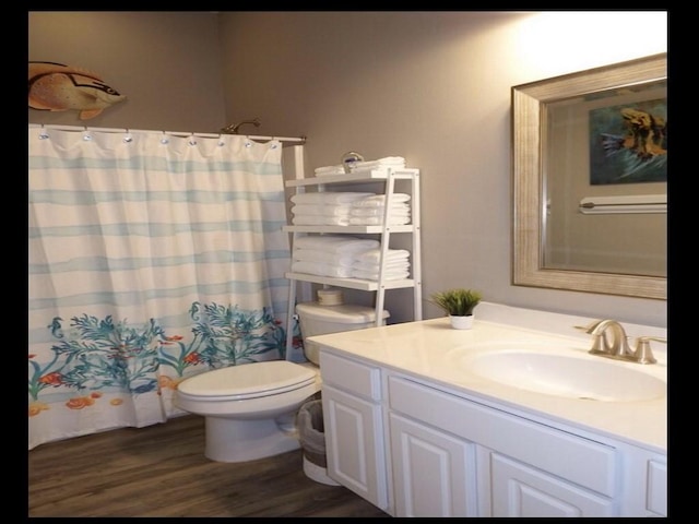 bathroom featuring hardwood / wood-style floors, vanity, a shower with shower curtain, and toilet