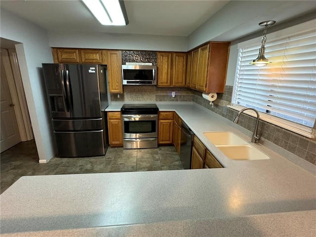 kitchen featuring appliances with stainless steel finishes, backsplash, pendant lighting, and sink