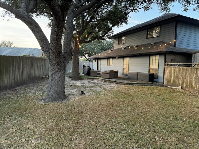 back of house with outdoor lounge area and a yard