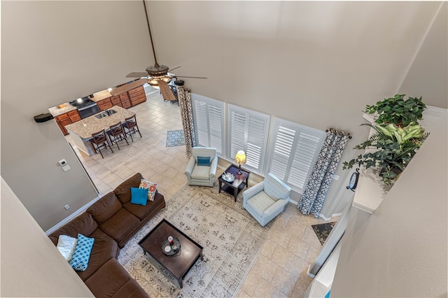 living room with a high ceiling and ceiling fan