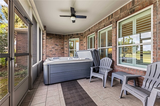 sunroom / solarium featuring ceiling fan, a healthy amount of sunlight, and a jacuzzi